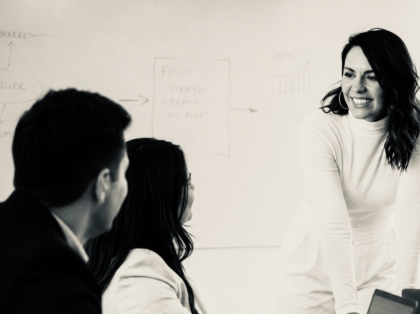 Vanessa Smith leading a business strategy meeting at a whiteboard